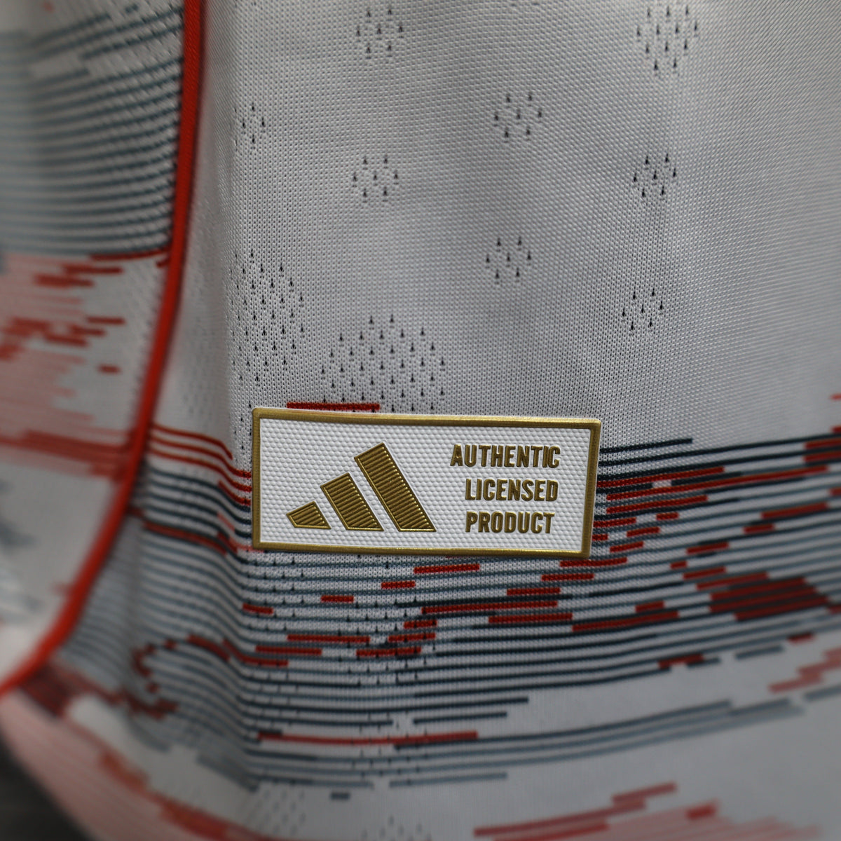 2025/26 Bayern Munich Away Player Version Jersey - White Body Red & Grey Horizontal Brushstroke Graphic - Orange Sleeve Cuffs - Black Adidas Three Stripes - FC Bayern Crest - Deutsche Telekom T Logo