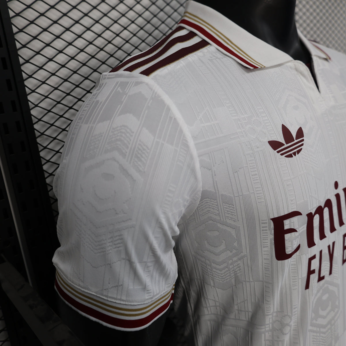 2025/26 Arsenal Away Player Version Jersey - White Body All-Over Tonal Emirates Stadium Architectural Line Emboss Pattern Deep Maroon Polo Collar Multi-Stripe Gold Red White Trim -Arsenal Cannon Crest - Emirates Fly Better